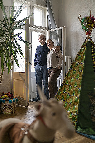 Älteres Ehepaar steht am Fenster im Kinderzimmer
