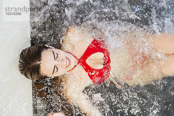 Lächelnde Frau genießt den Whirlpool in einem Spa