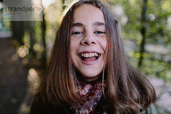 Porträt eines lachenden jungen Mädchens in einem Park