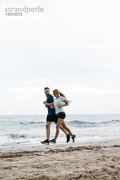 Junges Paar beim Joggen am Strand