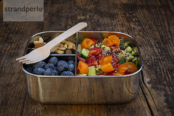 Hochwinkelansicht einer frischen Mahlzeit in einer Lunchbox mit Gabel auf einem Holztisch