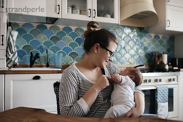 Porträt einer jungen Frau mit einem Baby zu Hause