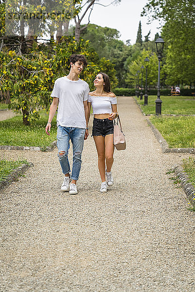 Junges Paar beim gemeinsamen Spaziergang in einem Park