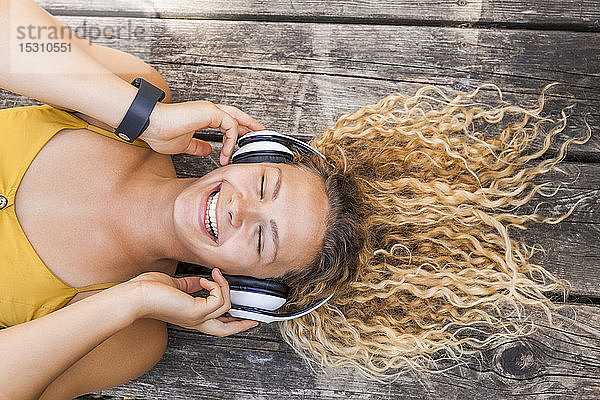 Lächelnde Frau  die im Freien Musik hört