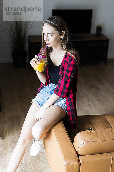 Junge Frau mit einem gesunden Getränk zu Hause