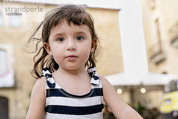 Bildnis eines süßen kleinen Mädchens im Sommer in einem gestreiften Kleid