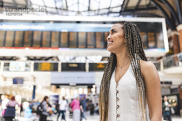 Glückliche junge Frau am Bahnhof  London  UK