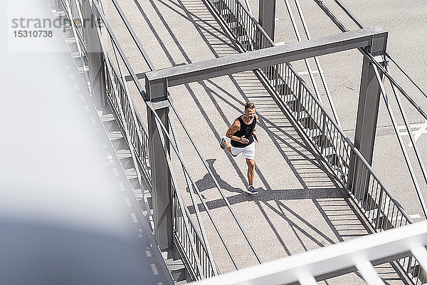 Sportlicher Mann joggt über die Brücke