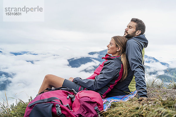 Liebevolles junges Paar auf einer Wanderung in den Bergen bei einer Pause  Herzogstand  Bayern  Deutschland