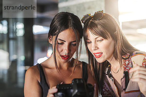 Zwei junge Frauen überprüfen Fotos auf einer Kamera