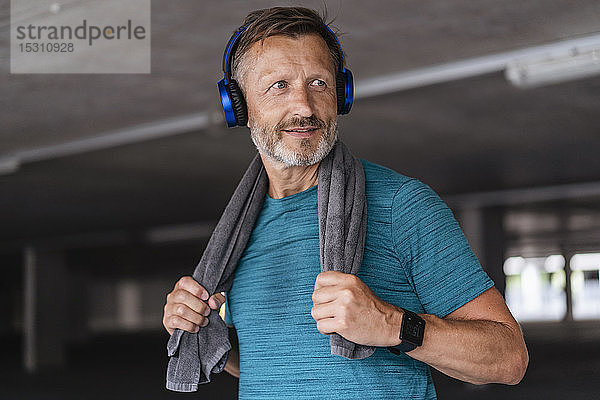 Sportlicher Mann trägt Kopfhörer nach dem Training