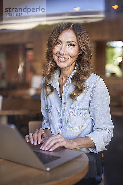 Geschäftsfrau mit Laptop in einem Café
