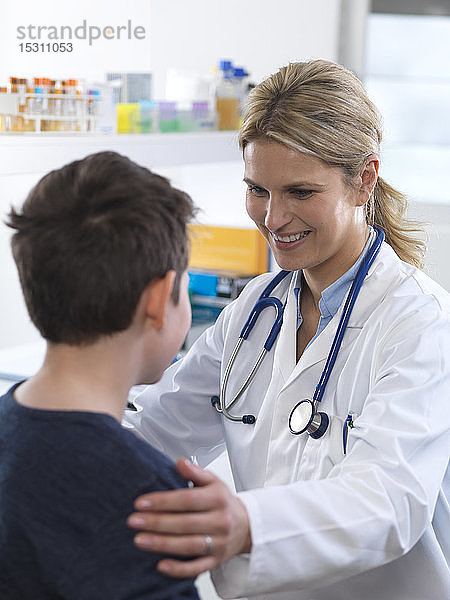 Ärztin gibt einem Jungen bei einem Termin in der Klinik eine Anleitung