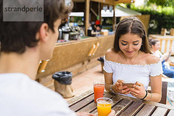 Junges Paar in einem Café  Frau benutzt Smartphone