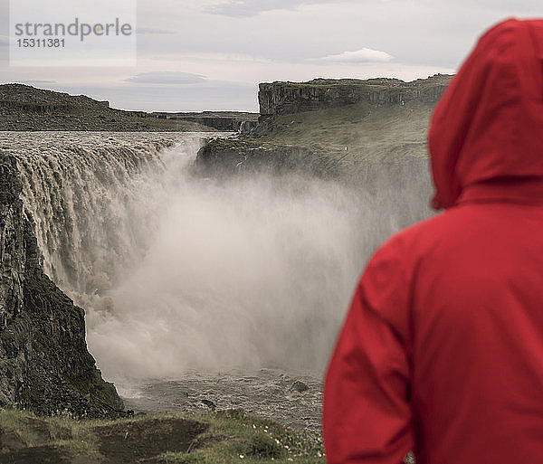 Junge Frau mit Blick auf die Dettifoss-Wasserfälle  Island