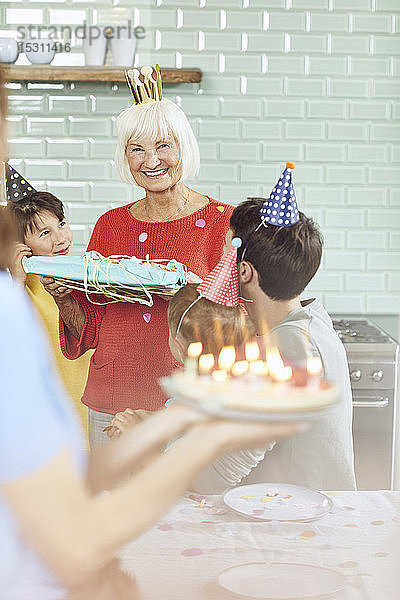 Enkelkinder  die den Geburtstag ihrer Großmutter zu Hause feiern
