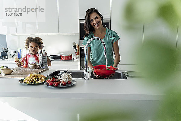 Glückliche Mutter und Tochter kochen gemeinsam in der Küche