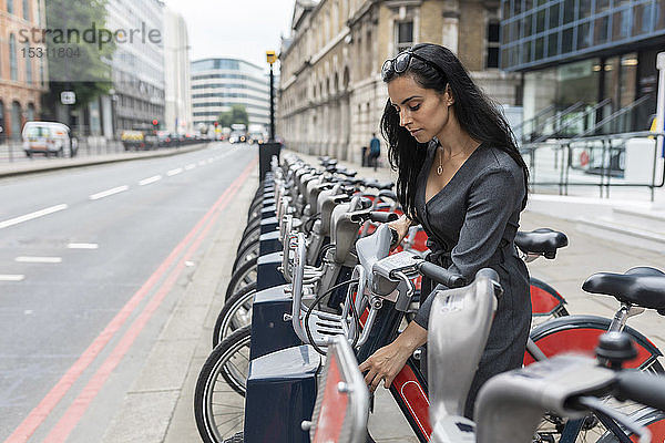 Frau in der Stadt nutzt Fahrradverleih zum Pendeln  London  UK