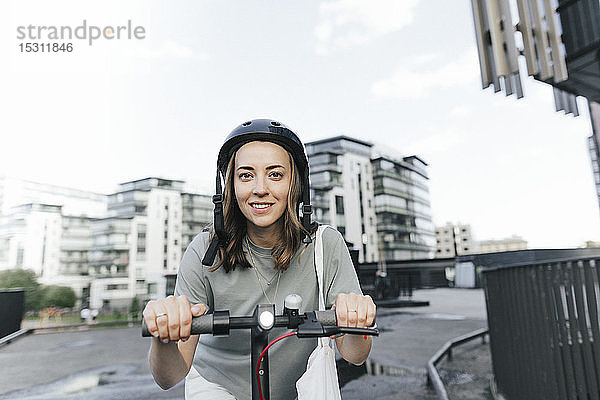 Frau mit E-Scooter und Helm