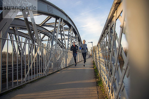 Zwei Teenager rennen über eine Eisenbahnbrücke