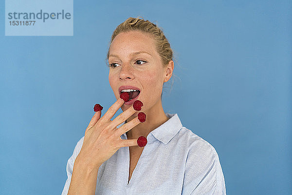 Bildnis einer blonden Frau mit Himbeeren an den Fingern