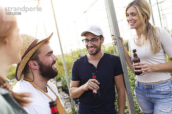 Eine Gruppe von Freunden trinkt Bier und genießt die Zeit im Gewächshaus
