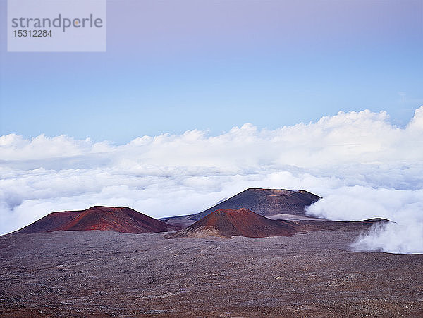 Idyllischer Blick auf den Vulkankrater Mauna Kea inmitten von Wolken vor blauem Himmel