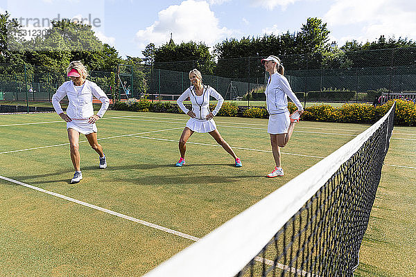 Reife Frauen machen vor dem Tennisspielen Dehnungsübungen