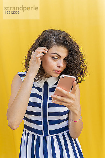 Porträt einer jungen Frau  die ein Smartphone benutzt