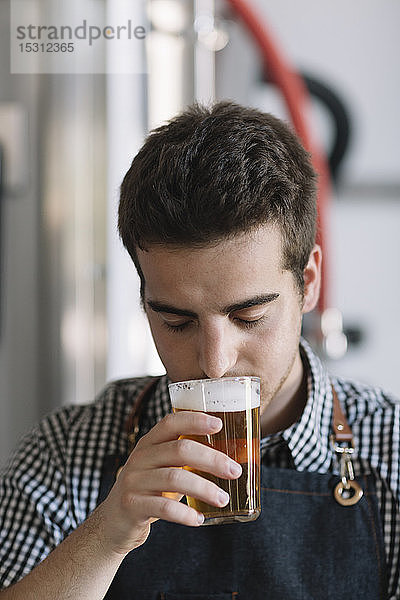 Junger Mann testet Bier in einer Brauerei