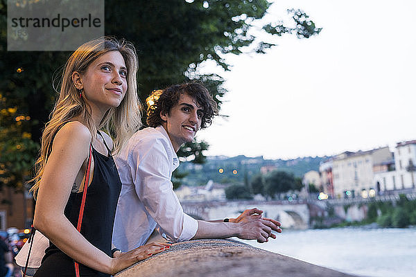 Glückliches junges Paar lehnt am Brückengeländer  Verona  Italien