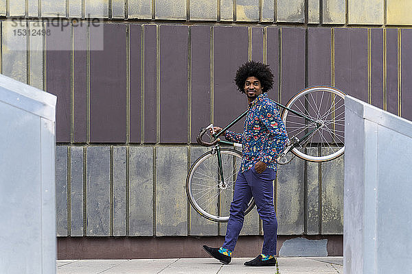 Stilvoller Mann mit Fahrrad in der Stadt