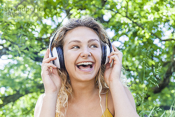 Lächelnde Frau  die Musik hört und zur Seite schaut