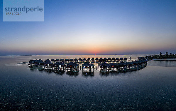Malediven  Insel Olhuveli  Resort-Bungalows auf der Lagune des Süd Male Atolls bei Sonnenuntergang