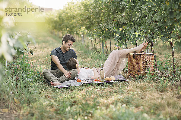 Junges verliebtes Paar beim Picknick in den Weinbergen