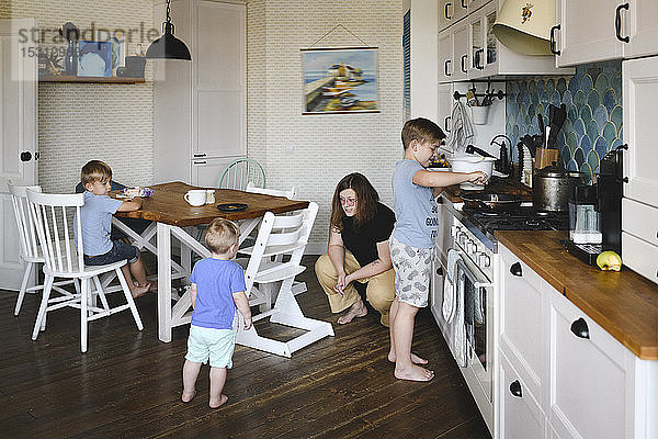 Mutter mit ihren drei Söhnen in der Küche