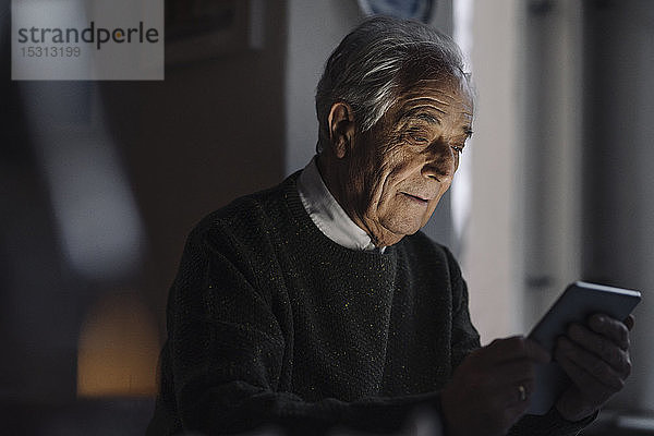 Älterer Mann benutzt Tablette zu Hause