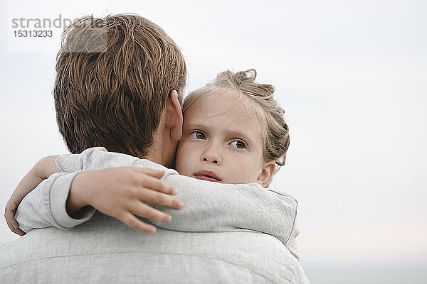 Porträt eines kleinen Mädchens  das seinen Vater umarmt