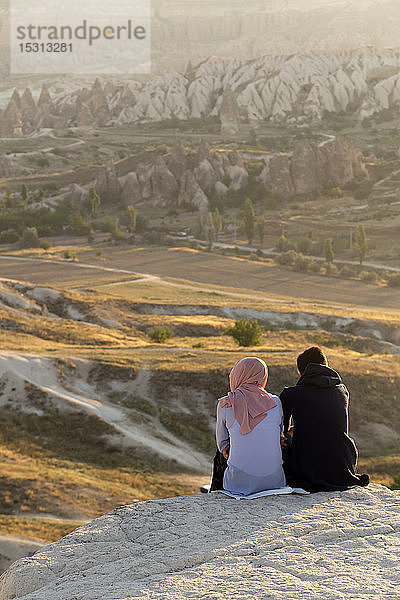 Ehepaar genießt den Blick auf felsige Landschaft in der Abenddämmerung  Goreme  Kappadokien  Türkei