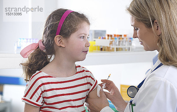 Ärztin gibt einem jungen Mädchen in der Klinik eine Routineimpfung