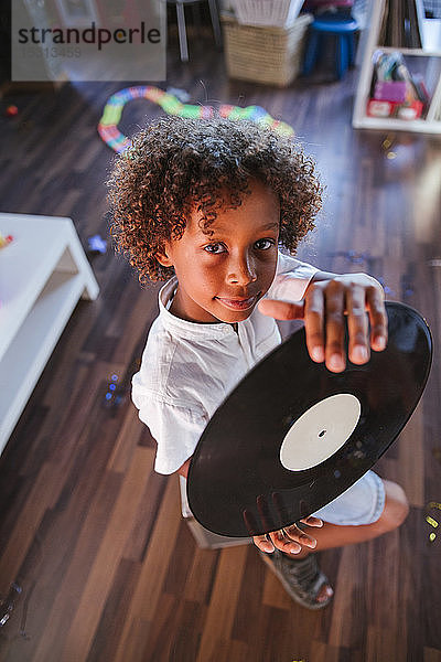Porträt eines jungen DJs mit Schallplatte