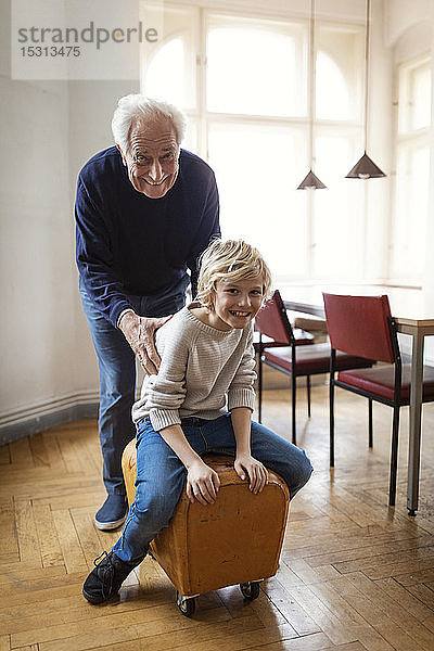 Glücklicher Großvater und Enkel spielen zu Hause mit Bock