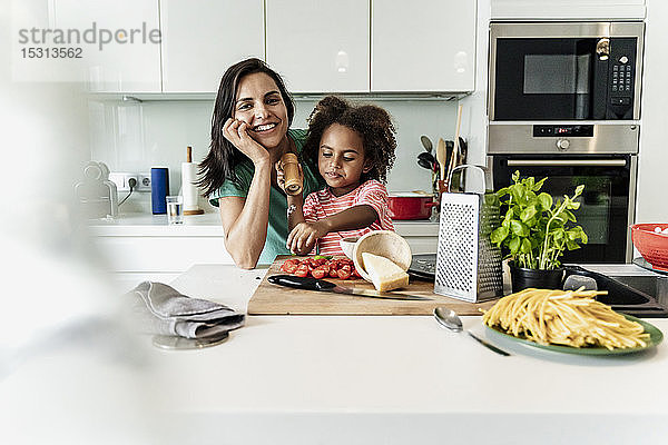 Porträt einer glücklichen Mutter und Tochter beim gemeinsamen Kochen in der Küche