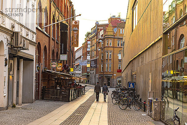 Rückansicht von Menschen  die auf der Straße inmitten von Wohngebäuden in der Stadt Malmö gehen