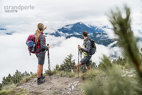 Junges Paar auf einer Wanderung in den Bergen mit Blick auf die Aussicht  Herzogstand  Bayern  Deutschland