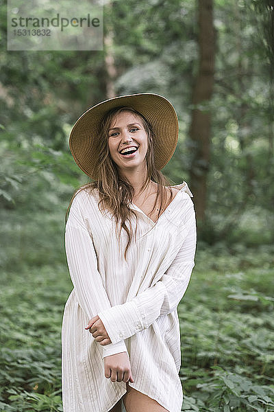 Porträt einer lachenden jungen Frau in einem Wald