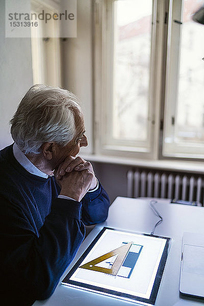 Älterer Mann benutzt Tablett mit Architekturplan
