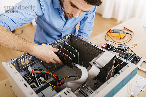 Techniker  der einen Desktop-Computer repariert und eine Leiterplatte austauscht