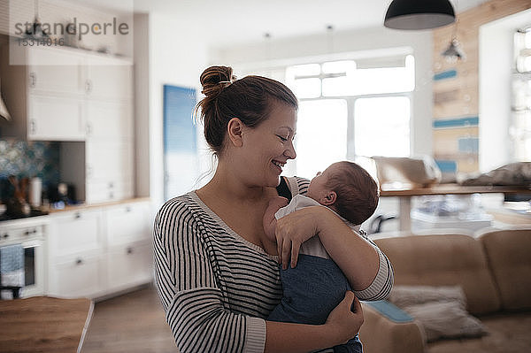 Porträt einer jungen Frau mit einem Baby zu Hause