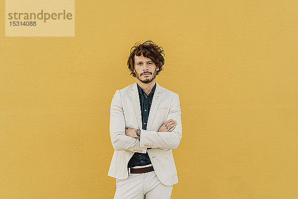 Porträt eines seriösen Geschäftsmannes vor gelber Wand